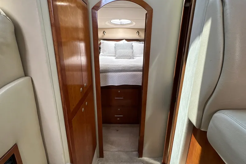 Slide: The Image of 2004 Cruisers Yachts 405 Express Motoryacht interior with cozy bedroom and wooden cabinetry. - 65
