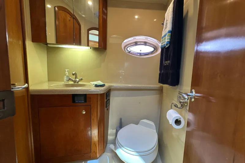 Slide: The Image of Luxurious bathroom in 2004 Cruisers Yachts 405 Express Motoryacht with wood cabinetry and porthole. - 66