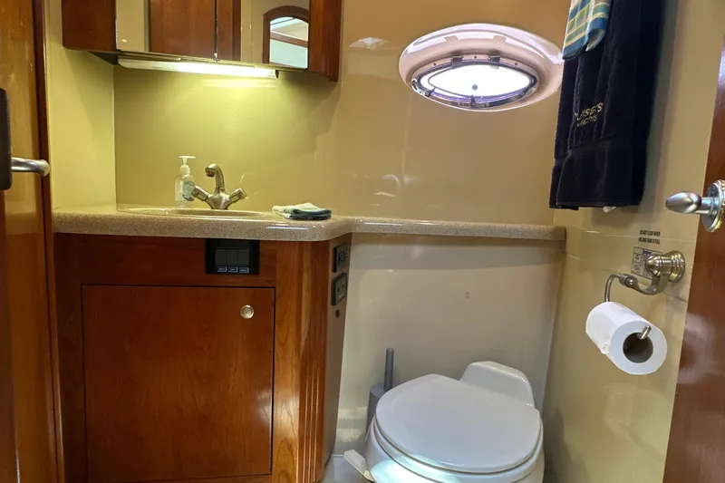 Slide: The Image of 2004 Cruisers Yachts 405 Express Motoryacht bathroom with sink, toilet, and porthole window. - 67