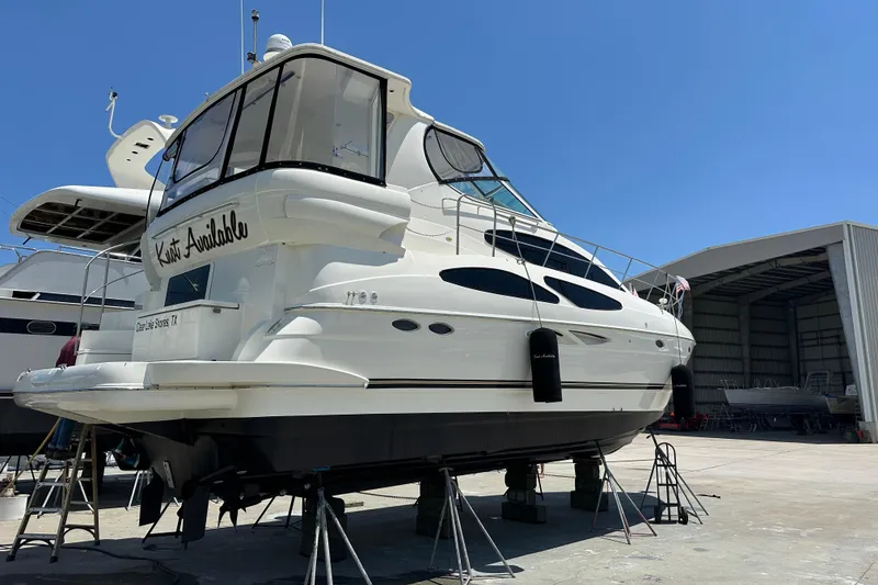 Slide: The Image of 2004 Cruisers Yachts 405 Express Motoryacht on stands, in a marina setting. - 93