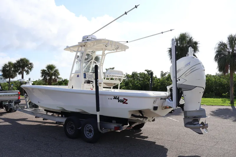 Slide: The Image of 2019 SeaVee 270Z boat on trailer with Mercury outboard, parked near palm trees. - 6