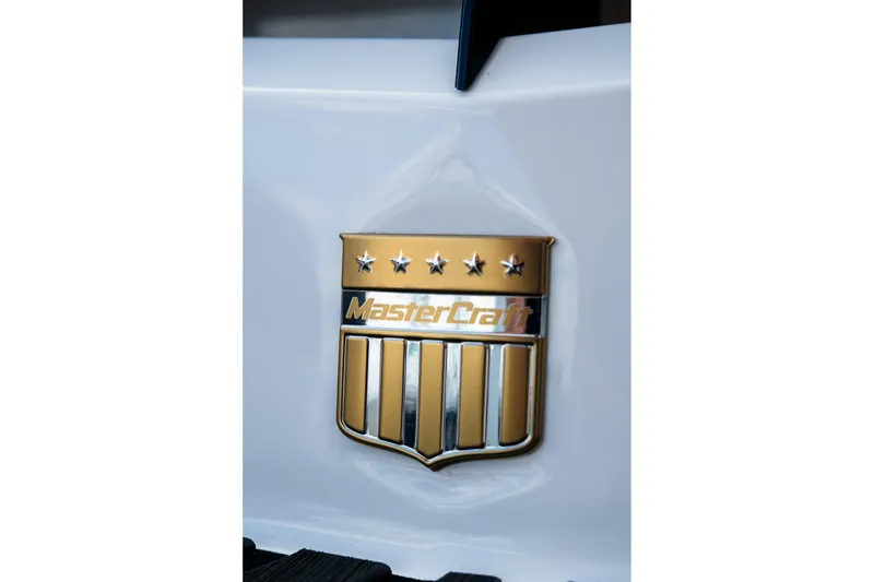 Slide: The Image of Gold MasterCraft emblem on 2026 XStar 25 boat, featuring stars and stripes design. - 13