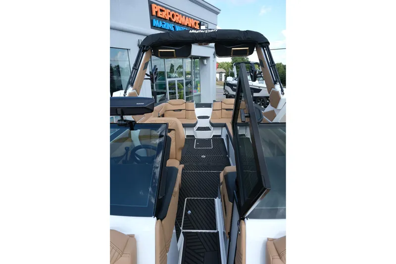 Slide: The Image of 2026 MasterCraft XStar 25 boat interior with tan seating and black flooring at Performance Marine. - 25