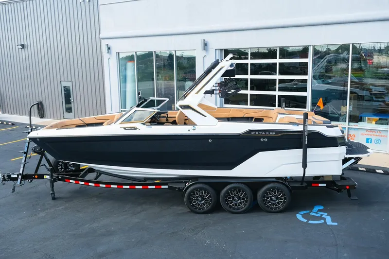 Slide: The Image of 2026 MasterCraft XStar 25 boat on trailer, parked outside a building. - 3