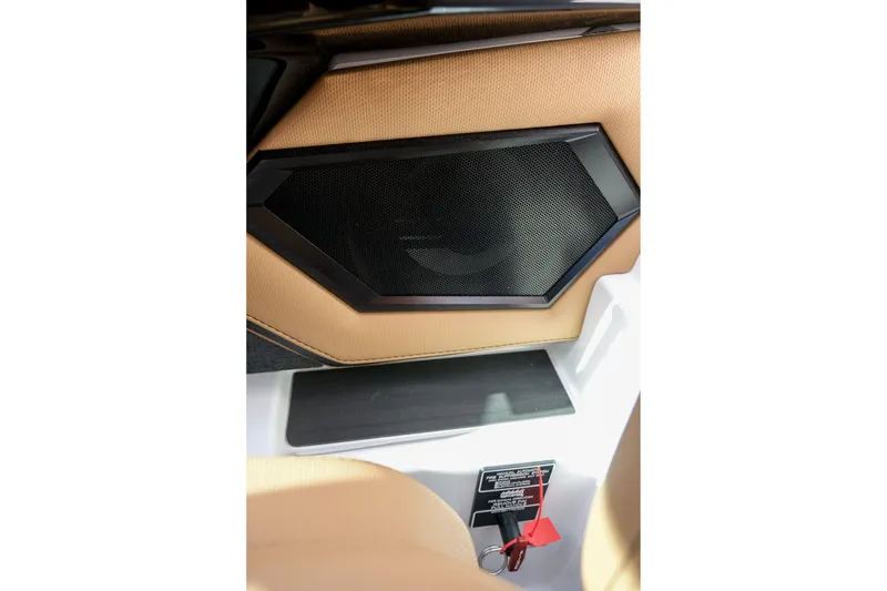 Slide: The Image of 2026 MasterCraft XStar 25 interior speaker detail with beige upholstery and safety key. - 42