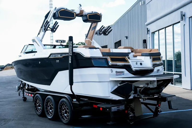 Slide: The Image of 2026 MasterCraft XStar 25 boat on trailer, sleek design, parked outside a modern building. - 6