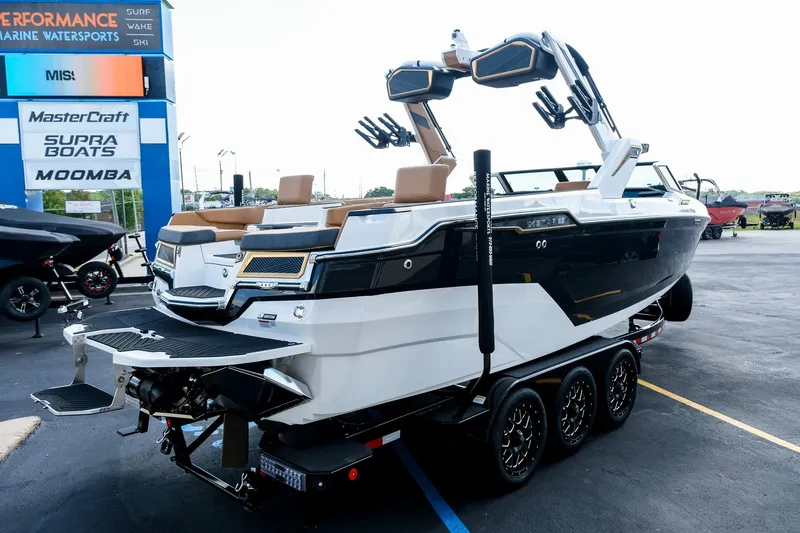 Slide: The Image of 2026 MasterCraft XStar 25 boat on trailer at dealership, showcasing sleek design and modern features. - 9