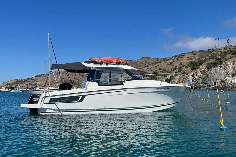 Slide: The Image of 2023 Jeanneau NC Weekender 695 Series 2 boat anchored in scenic coastal waters. - 1