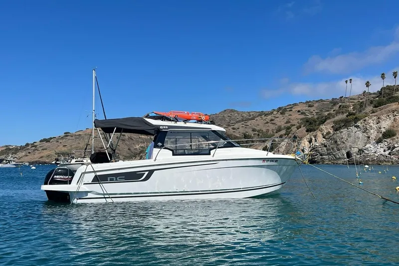 Slide: The Image of 2023 Jeanneau NC Weekender 695 Series 2 boat anchored in scenic coastal waters. - 2