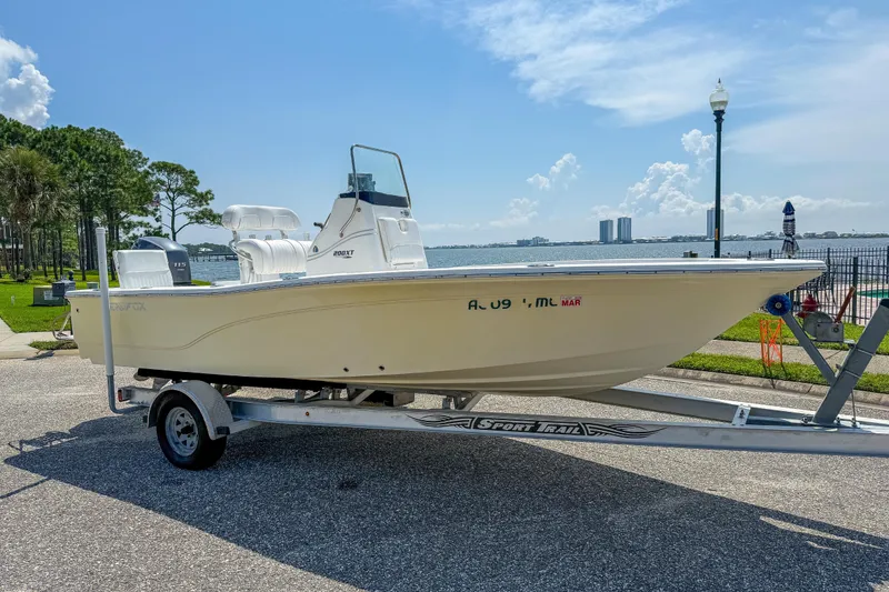 Slide: The Image of 2013 Sea Fox 200XT boat on trailer by waterfront, clear sky background. - 0