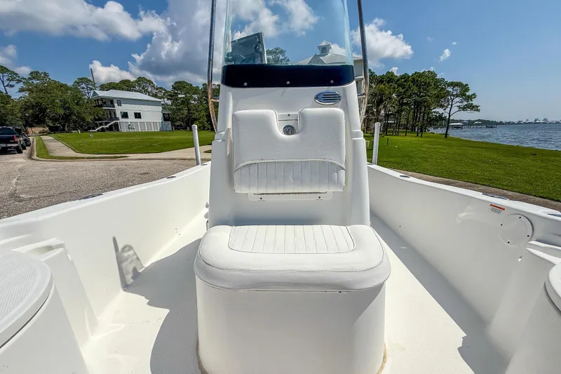 Slide: The Image of 2013 Sea Fox 200XT boat interior with white seating, near waterfront and greenery. - 12