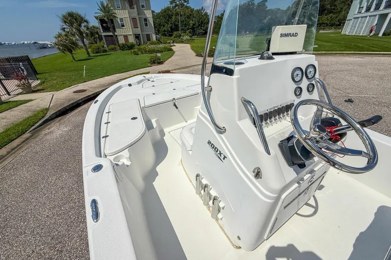 Slide: The Image of 2013 Sea Fox 200XT boat with steering console, parked near waterfront homes. - 16