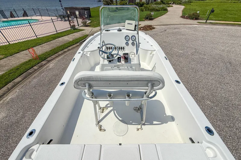 Slide: The Image of 2013 Sea Fox 200XT boat interior with steering console, docked near a pool and waterfront. - 18