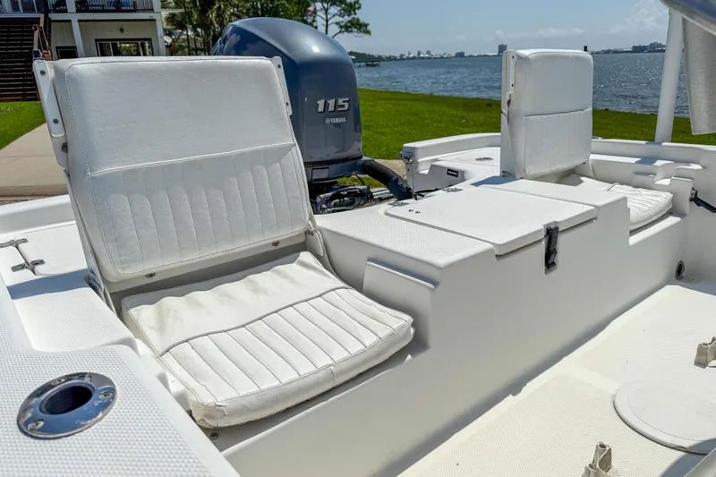 Slide: The Image of 2013 Sea Fox 200XT boat interior with Yamaha 115 engine, featuring white seating and lake view. - 23