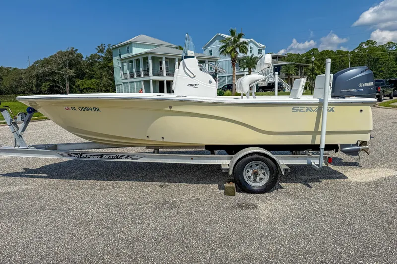 Slide: The Image of 2013 Sea Fox 200XT boat on trailer, parked in residential area under clear blue sky. - 8