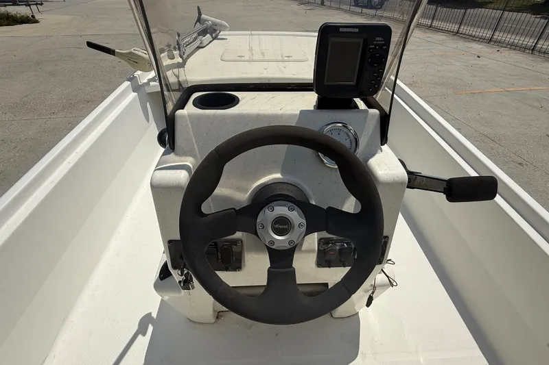 Slide: The Image of 2013 Mako Pro Skiff 17 CC boat console with steering wheel and navigation equipment. - 12