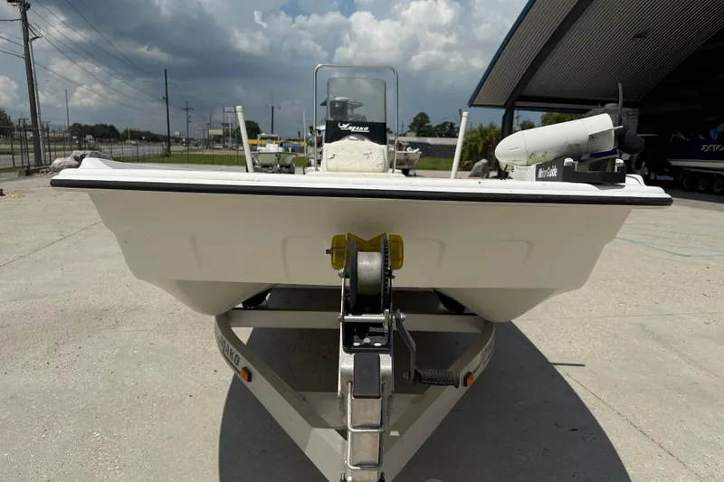 Slide: The Image of 2013 Mako Pro Skiff 17 CC boat on trailer, parked outdoors under cloudy sky. - 3