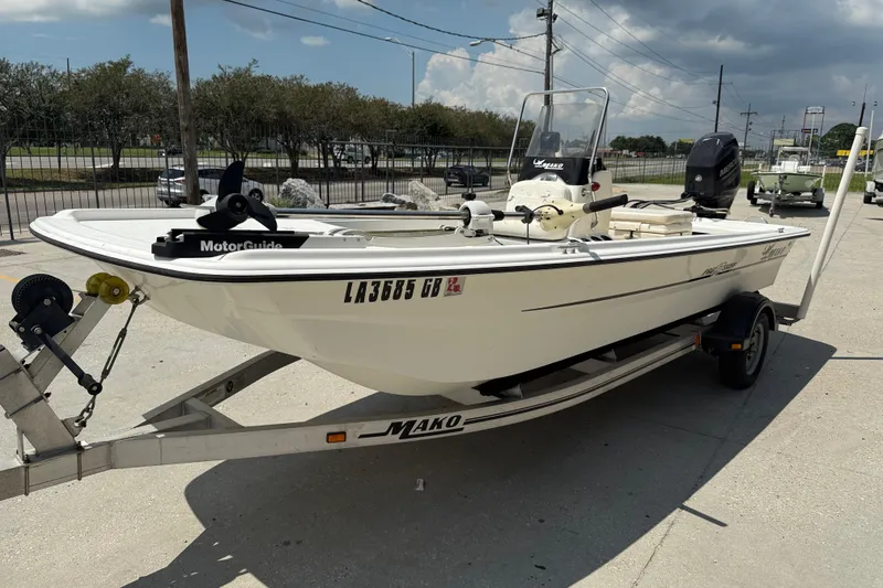 Slide: The Image of 2013 Mako Pro Skiff 17 CC boat on trailer, parked outdoors under cloudy sky. - 4