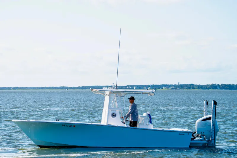 Slide: The Image of 1979 SeaCraft SF23 boat on water with person steering, clear sky background. - 2