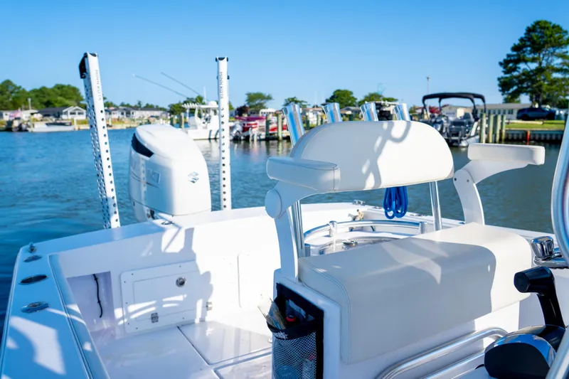 Slide: The Image of 1979 SeaCraft SF23 boat with white seating, docked by a scenic waterfront. - 8