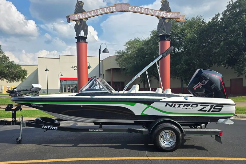 Slide: The Image of 2020 Nitro Z19 Sport boat on trailer, parked outdoors near "Tracker Country" sign. - 0