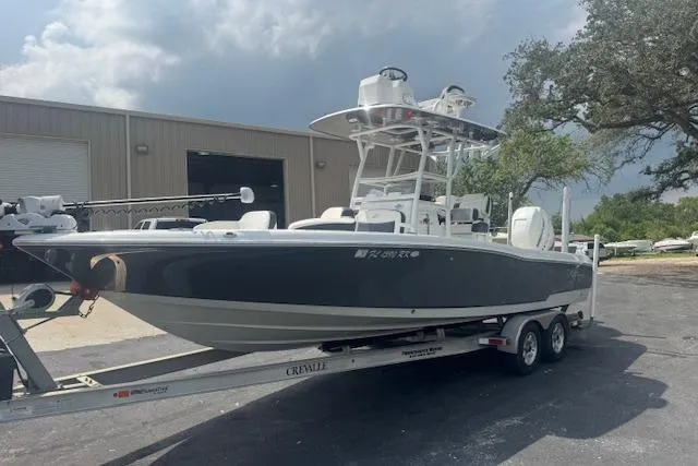 Slide: The Image of 2018 Crevalle 26 HBW boat on trailer, parked outdoors near a warehouse. - 8
