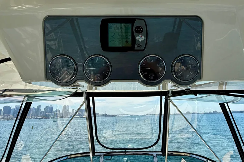 Slide: The Image of 2007 Sea Ray 52 Sedan Bridge helm with gauges, overlooking city skyline and ocean. - 16