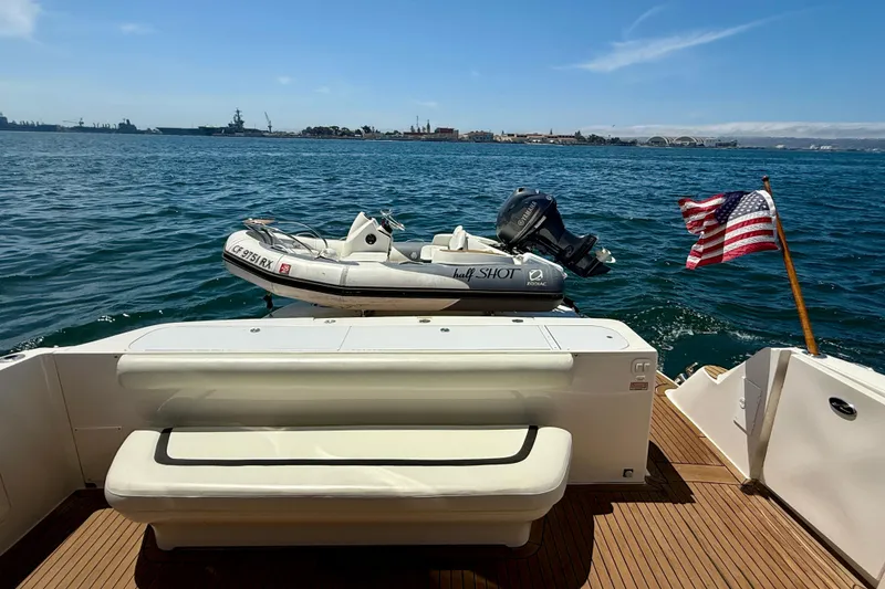 Slide: The Image of 2007 Sea Ray 52 Sedan Bridge yacht with dinghy and American flag on open water. - 17