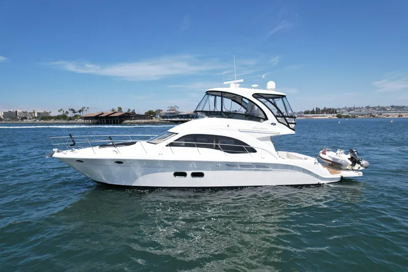 Slide: The Image of 2007 Sea Ray 52 Sedan Bridge yacht cruising on a sunny day near the coastline. - 2