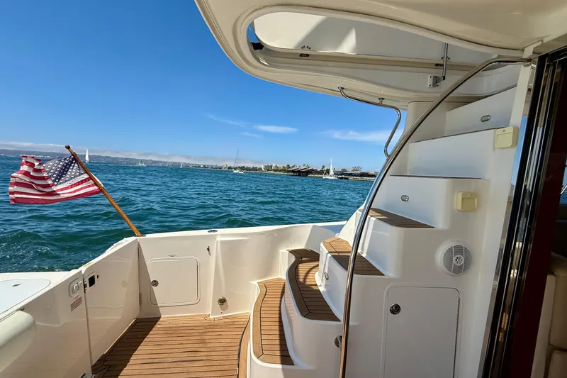 Slide: The Image of 2007 Sea Ray 52 Sedan Bridge yacht with American flag, ocean view, and elegant staircase. - 25