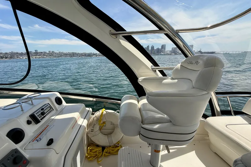Slide: The Image of 2007 Sea Ray 52 Sedan Bridge helm with city skyline view, featuring luxurious seating and controls. - 34