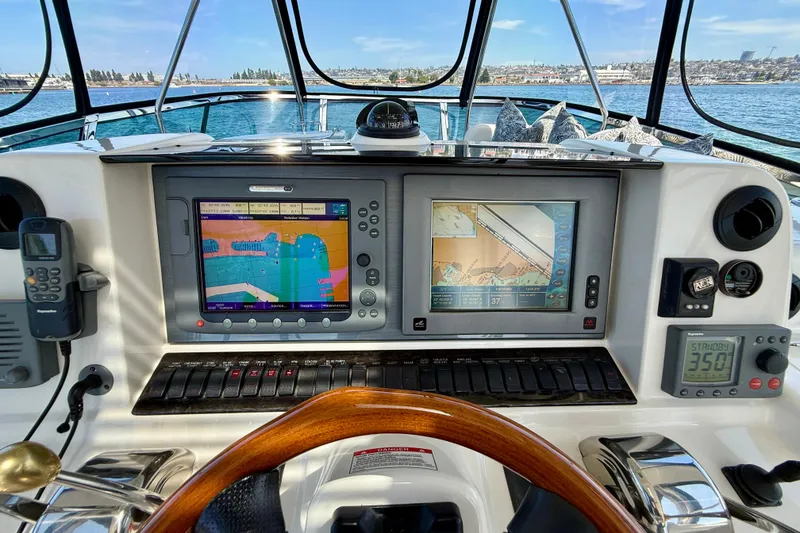 Slide: The Image of 2007 Sea Ray 52 Sedan Bridge helm with navigation screens and controls, overlooking the ocean. - 35