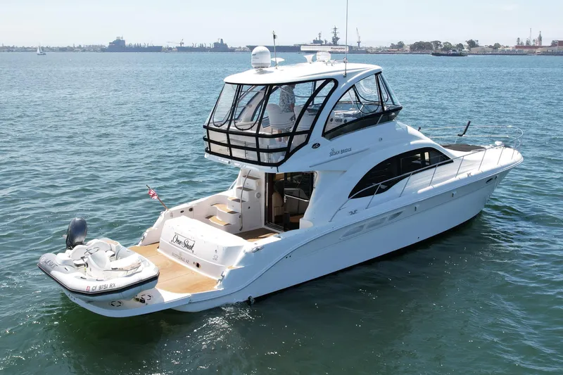 Slide: The Image of 2007 Sea Ray 52 Sedan Bridge yacht on calm water, featuring sleek design and spacious deck. - 4