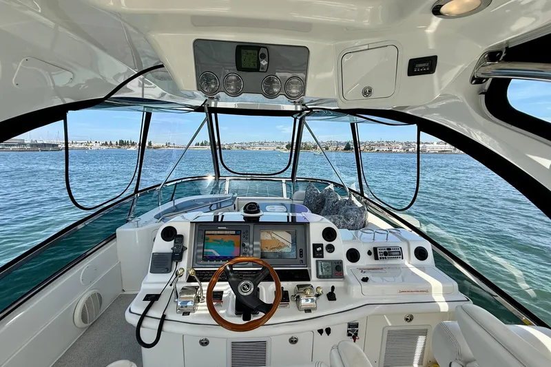 Slide: The Image of 2007 Sea Ray 52 Sedan Bridge helm with navigation screens, steering wheel, and ocean view. - 44
