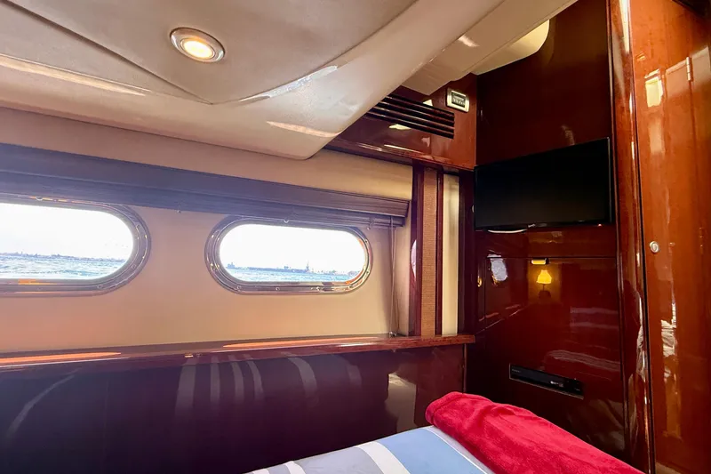 Slide: The Image of Luxurious 2007 Sea Ray 52 Sedan Bridge cabin interior with porthole windows and sleek wood finish. - 57