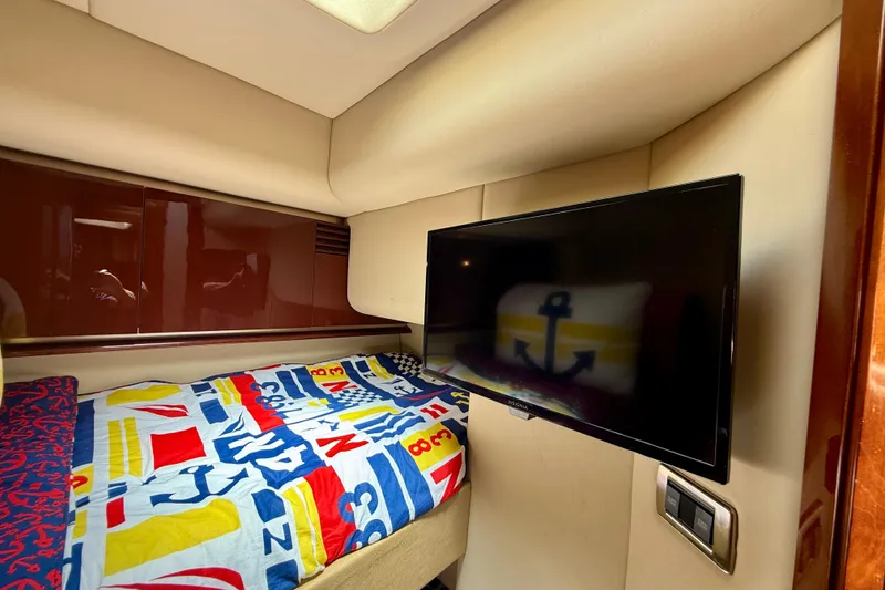 Slide: The Image of 2007 Sea Ray 52 Sedan Bridge cabin with colorful bedding and wall-mounted TV. - 61