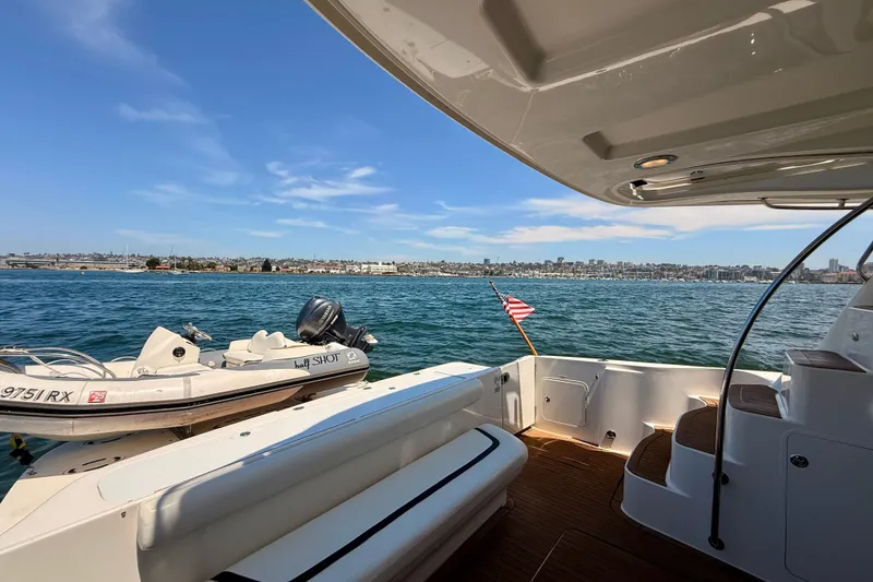 Slide: The Image of 2007 Sea Ray 52 Sedan Bridge yacht with scenic waterfront view and small boat. - 85