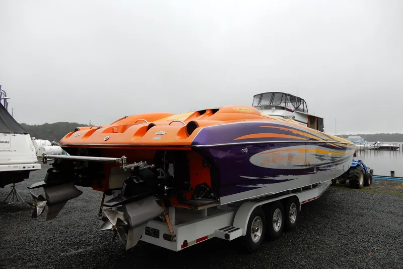 Slide: The Image of 2008 Nor-Tech 3600 Supercat powerboat with vibrant orange and purple design on a trailer. - 10