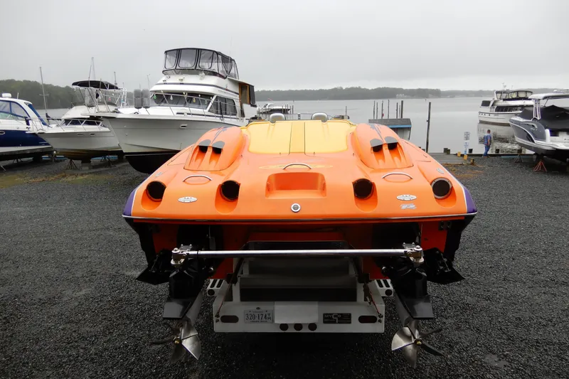 Slide: The Image of 2008 Nor-Tech 3600 Supercat in vibrant orange, docked among other boats. - 12