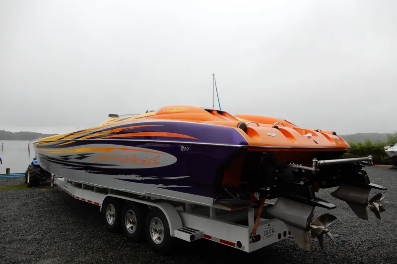 Slide: The Image of 2008 Nor-Tech 3600 Supercat powerboat with vibrant orange and purple design on a trailer. - 13