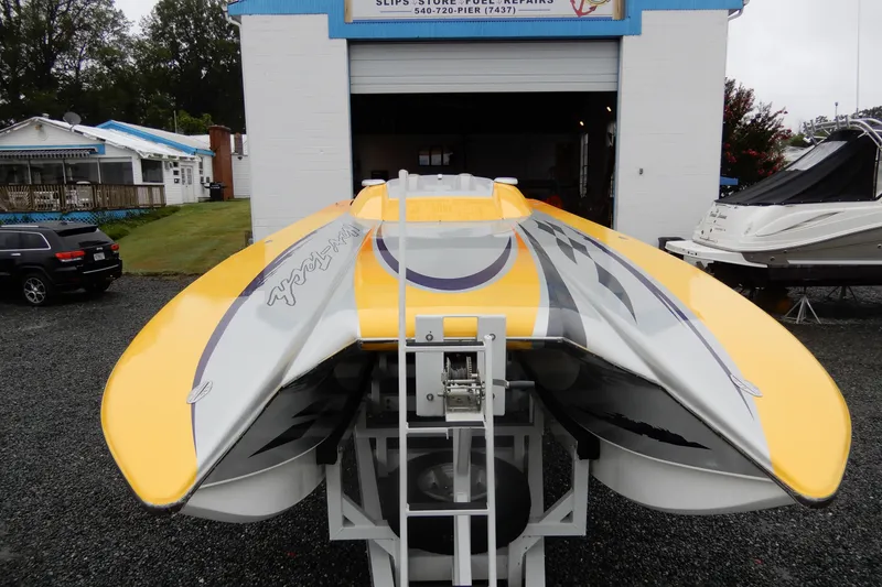 Slide: The Image of 2008 Nor-Tech 3600 Supercat powerboat with vibrant yellow and gray design, parked outside a garage. - 14
