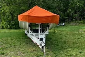Slide: The Image of 2008 Nor-Tech 3600 Supercat with orange cover on trailer, parked on grass. - 19