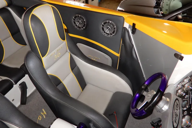 Slide: The Image of 2008 Nor-Tech 3600 Supercat interior with black and yellow seats, steering wheel, and speakers. - 24