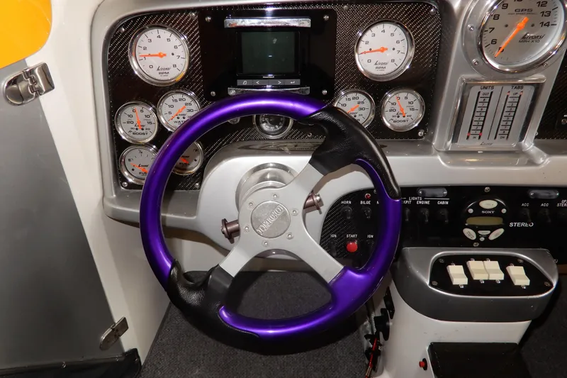 Slide: The Image of Dashboard of a 2008 Nor-Tech 3600 Supercat with purple steering wheel and gauges. - 26