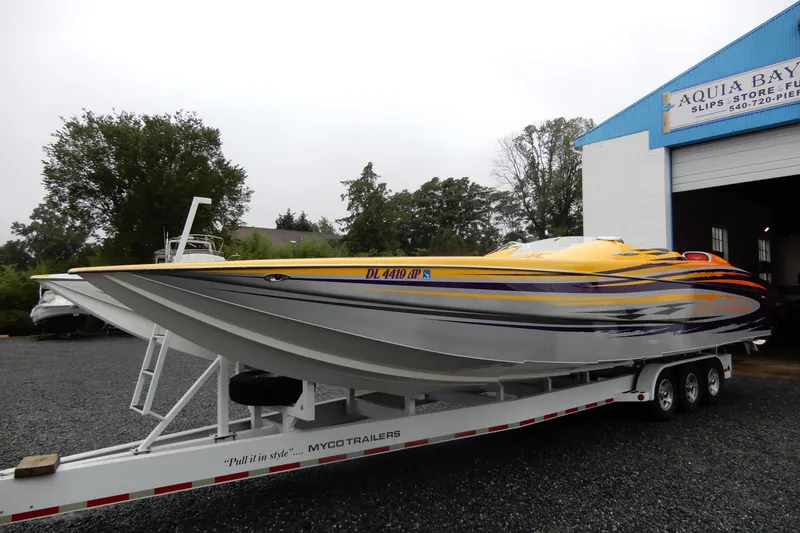 Slide: The Image of 2008 Nor-Tech 3600 Supercat powerboat on trailer, vibrant yellow and orange design. - 4