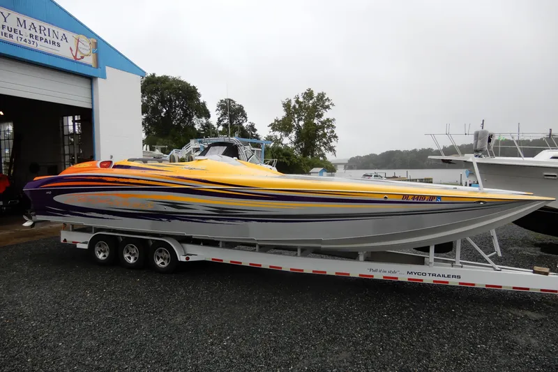 Slide: The Image of 2008 Nor-Tech 3600 Supercat powerboat on trailer, vibrant yellow and purple design. - 7