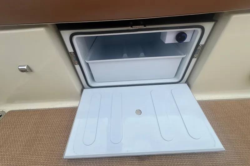 Slide: The Image of Open storage compartment on 2017 Chris-Craft Launch 28 boat, featuring a built-in cooler. - 6