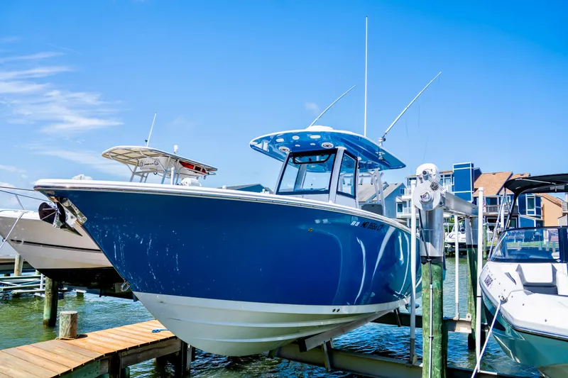 The Image of 2022 Sportsman Open 282 Center Console boat on calm water with a person onboard. - 0