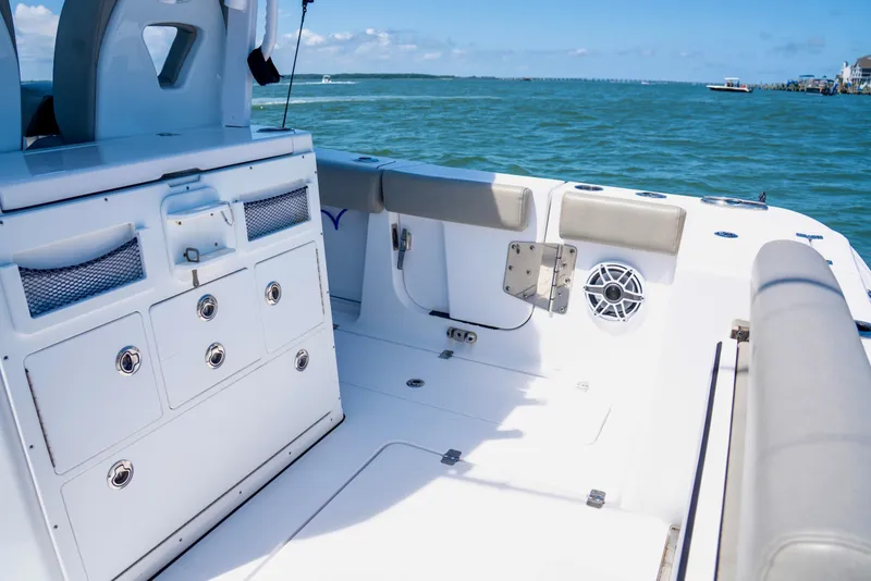Slide: The Image of 2022 Sportsman Open 282 Center Console boat interior with storage and seating, on open water. - 11