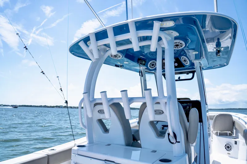 Slide: The Image of 2022 Sportsman Open 282 Center Console boat on water, featuring fishing rod holders. - 9